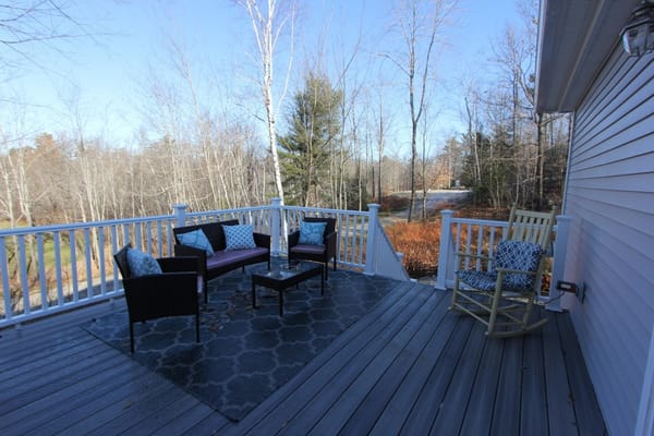 Outdoor seating area on a deck with forest view