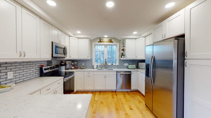 Modern kitchen interior with white cabinetry and stainless steel appliances