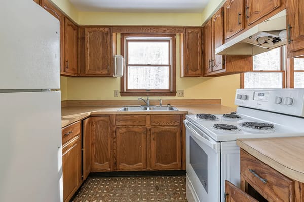 Bright kitchen featuring wooden cabinets and a white stove