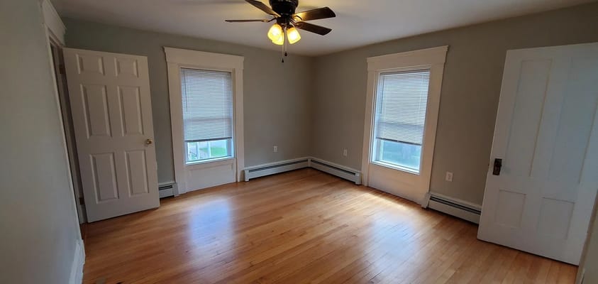 Bright living area with wooden floors and two windows
