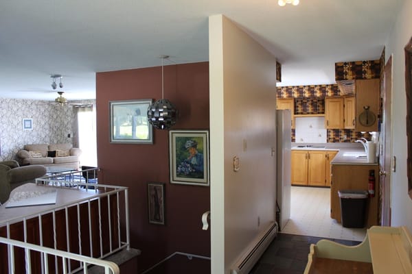 View of living area leading to the kitchen in a senior living facility.