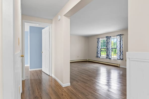 Spacious living area with wooden floors and natural light