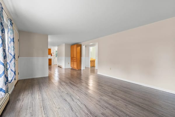 Spacious living room with wooden flooring and natural light