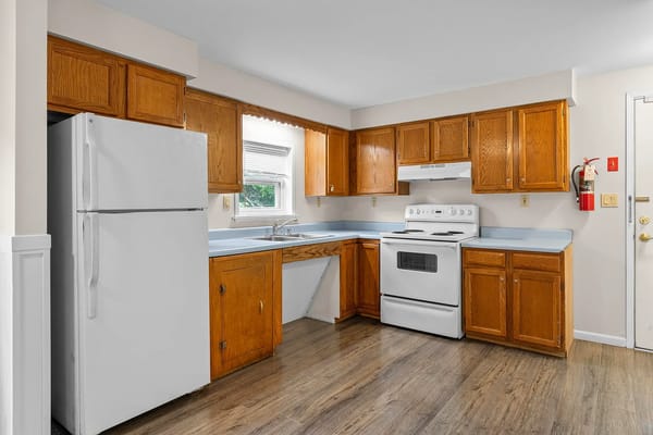Spacious kitchen with wooden cabinets and appliances.