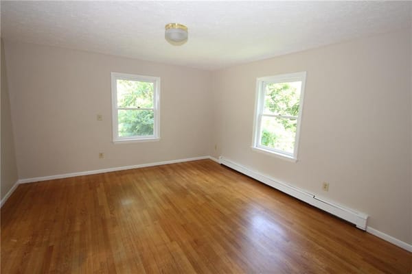 Empty room with hardwood floor and two windows