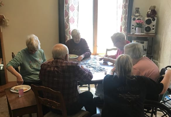 Residents working on a puzzle together in a common area