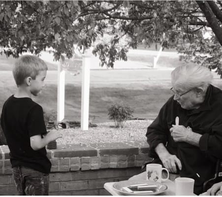 An elderly man and a young boy talking outdoors
