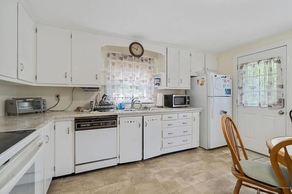 Bright kitchen with white cabinets and modern appliances