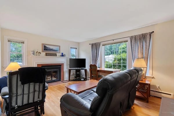 Spacious living room featuring a fireplace and large windows at Pine View Road Unit 1