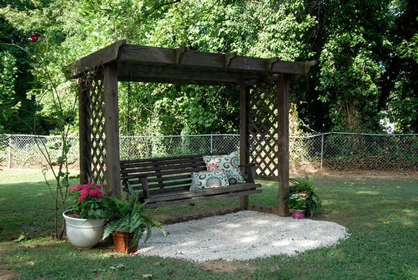 Outdoor seating area with a wooden arbor and plants