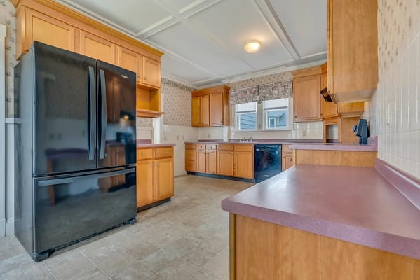 Modern kitchen with wooden cabinets and a black refrigerator