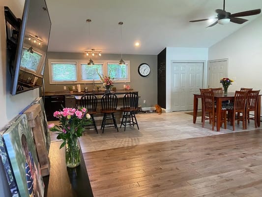 Bright kitchen and dining area with wooden furniture and flowers