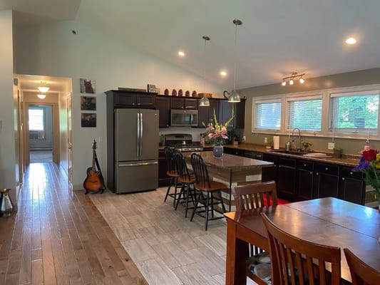 Spacious kitchen with dark cabinets and wooden dining table