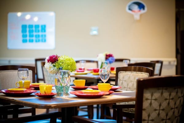 Dining table set with colorful plates and flowers