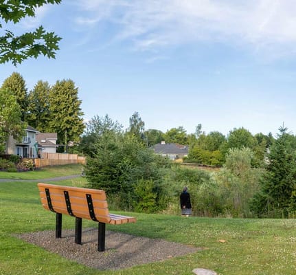 A resident enjoying the outdoor space by a bench