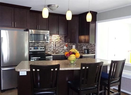 Stylish kitchen with dark cabinets and a fruit bowl on the counter