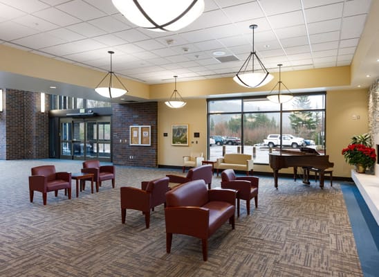 Bright interior of a common area with seating and piano