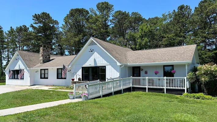 Exterior view of a senior care home with a garden