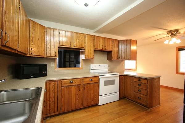 Bright and spacious kitchen with wooden cabinetry and appliances