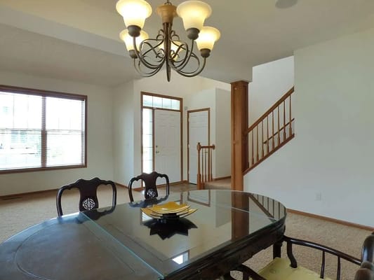 Bright common area with a dining table and chandelier