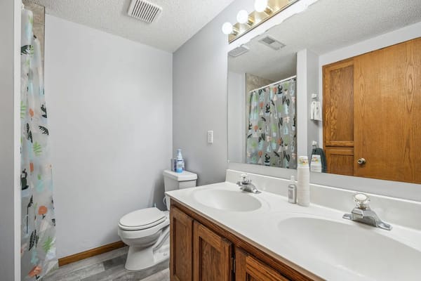 Spacious bathroom with double sinks and a shower curtain