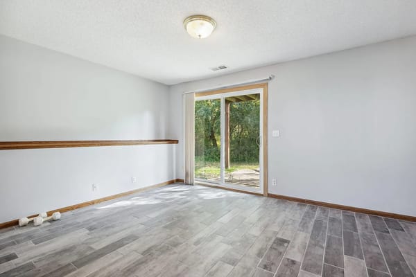 Bright living room with sliding glass door and wooden flooring