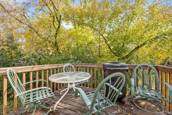 Outdoor seating area on a wooden deck surrounded by trees