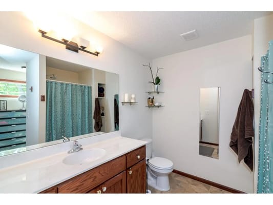 Clean bathroom with a sink, mirror, and light fixtures.