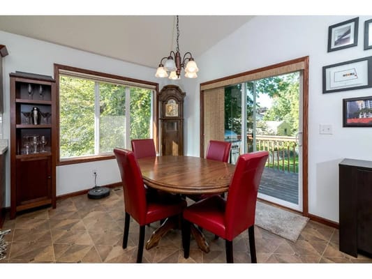 Cozy dining area with a round table and red chairs.