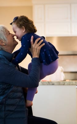 Senior resident playing with a young child in a cozy living area