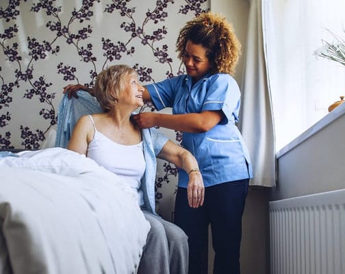 Caregiver assisting a resident in an interior room