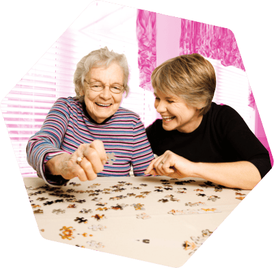 Resident enjoying a puzzle with a caregiver