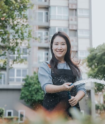 A staff member watering plants in an outdoor area