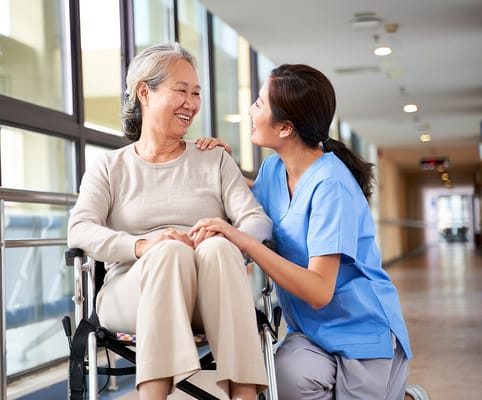 Caregiver interacting with a resident in a hallway