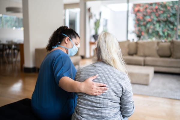 Caregiver comforting a resident in a warm interior setting