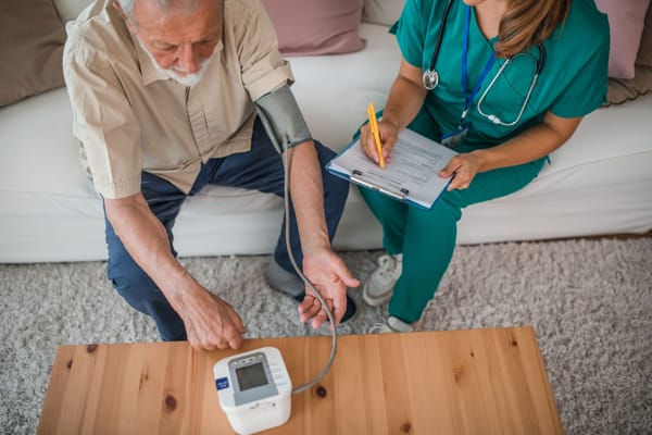 A nurse taking a patient's blood pressure in a cozy room