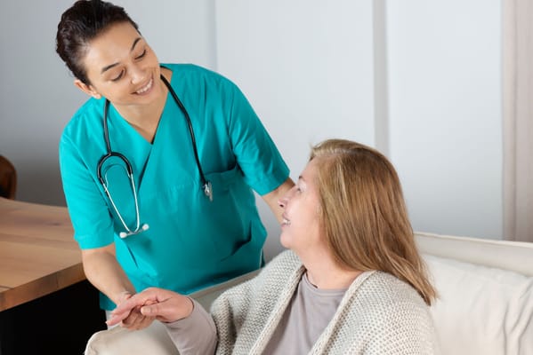 A caregiver smiling while assisting a resident