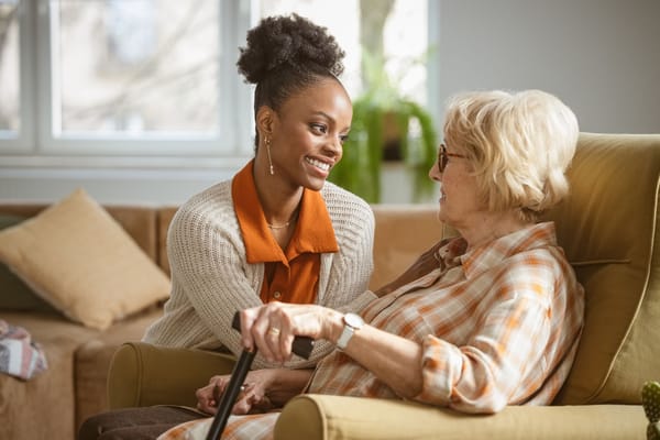 Caregiver interacting with an elderly resident in a cozy interior