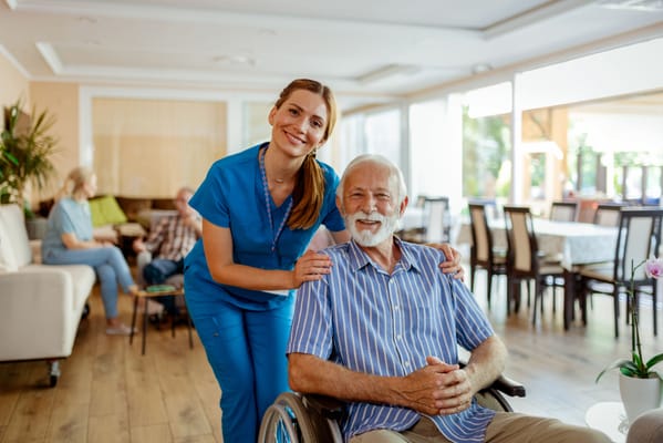 Nurse and elderly resident smiling in a common area