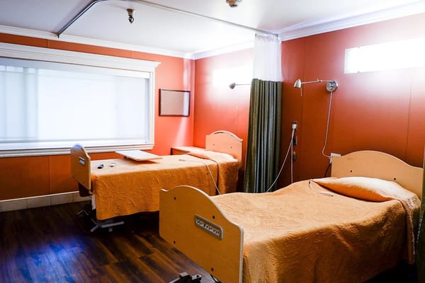Nursing room with two beds and a large window