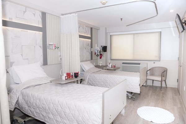 Brightly lit shared resident room with two beds