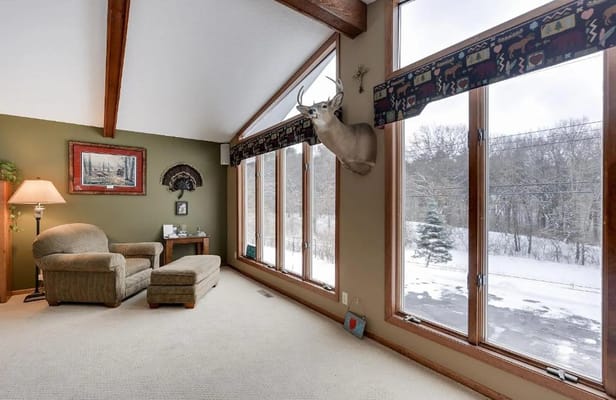 Spacious living room with large windows and a comfortable armchair
