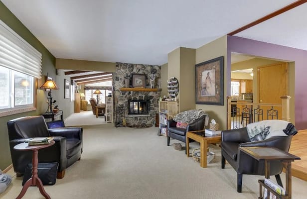 A cozy living room with a fireplace, comfortable seating, and warm decor.