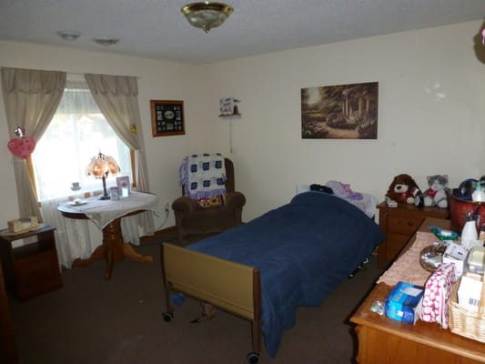 Bedroom with a bed, armchair, and decorative items.