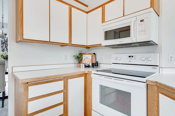 Bright and spacious kitchen with white cabinets and appliances