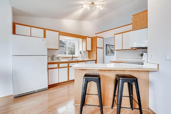Bright kitchen with wood cabinets and stools