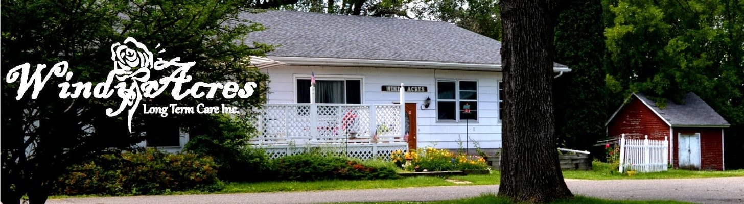 Exterior of Windy Acres Long Term Care facility, featuring a white house and red shed.