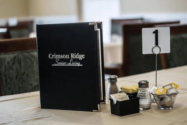 Dining table setup with menu and condiments at Crimson Ridge Meadows.
