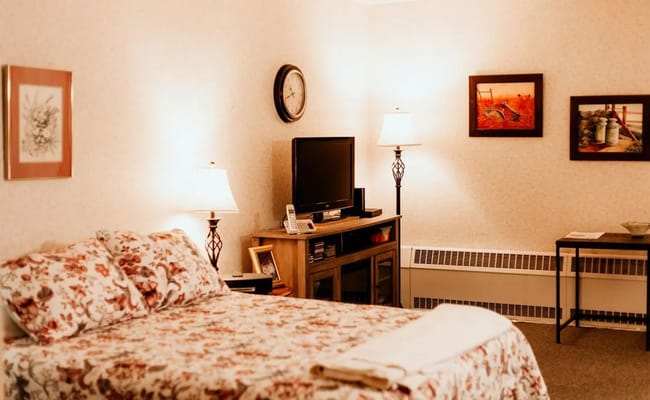 Cozy resident room with floral bedding and lamps