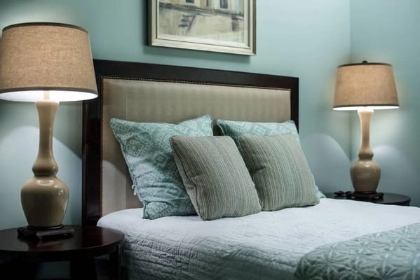 Stylish bedroom with a headboard, decorative pillows, and bedside lamps